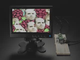 Video of DVI breakout board on breadboard with Raspberry Pico RP2040 hooked up with jumper wires. A small HDMI monitor displays a psychedelic animation with Raspberry Pi logos and bouncing middle-aged white man bust of Raspberry Pi founder. 