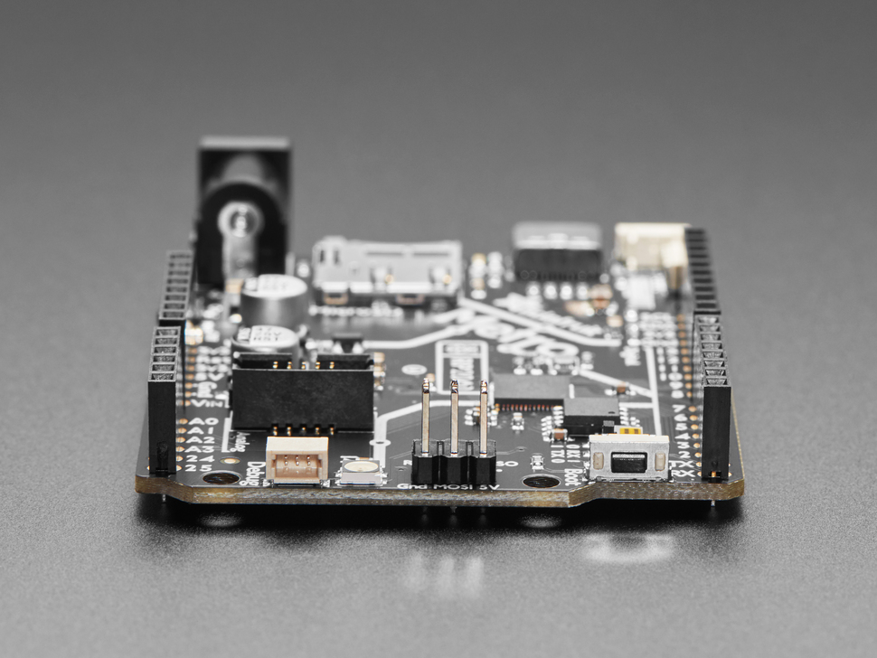 Side profile shot of STEMMA QT port and right-angle tactile button on dev board.