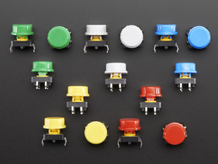 Top-down shot of 15 colorful round tactile button switches in green, yellow, red, blue, and white.