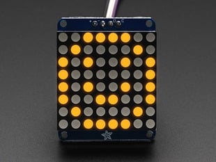 Adafruit Small 1.2" 8x8 Yellow LED Matrix w/I2C Backpack assembled and powered on. A yellow graphic smiley is displayed.