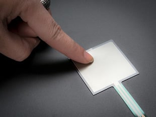 Finger pressing down on square force-sensitive sensor