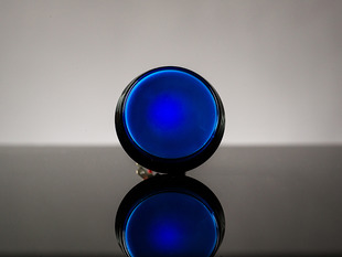 Head-on shot of illuminated large blue arcade button 60mm