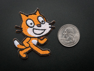 Embroidered badge in the shape of jaunty orange cat Scratch logo, with black outlines. 