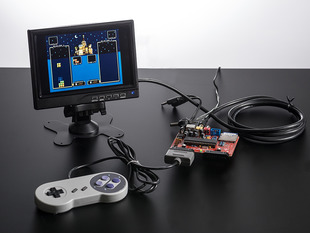 Assembled UZEBOX game board with SNES controller and TV showing a paused game of Tetris.