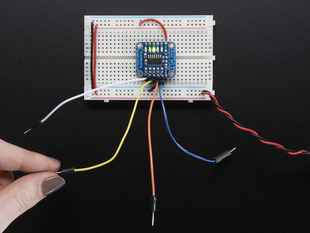Standalone 5-Pad Capacitive Touch Sensor Breakout on breadboard with hand touching an attached wire