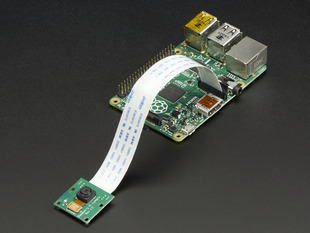 Angled shot of Raspberry Pi Camera Board connected to a flex cable and a Raspberry Pi.