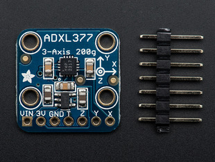 Top down view of a ADXL377 - High-G Triple-Axis Accelerometer next to a 7-pin header. 
