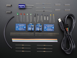 Collection of doubled-up loose components in kit: PCBs, XBees, connectors, ribbon cable, and other parts.