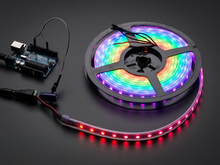 Adafruit NeoPixel Digital RGB LED Strip reel wired to a microcontroller, with all the LEDs in a rainbow