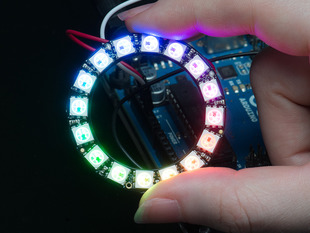 Hand holding NeoPixel Ring with 16 x 5050 RGB LED, lit up rainbow