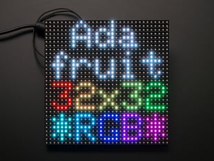 Assembled and powered on 32x32 RGB LED Matrix Panel - 6mm pitch. The matrix lights up "Adafruit 32x32 *RGB*"