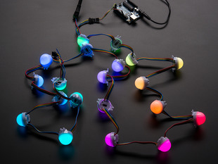 Cluster of many lit up LED pixel hemispheres on wire strand, rainbow colored