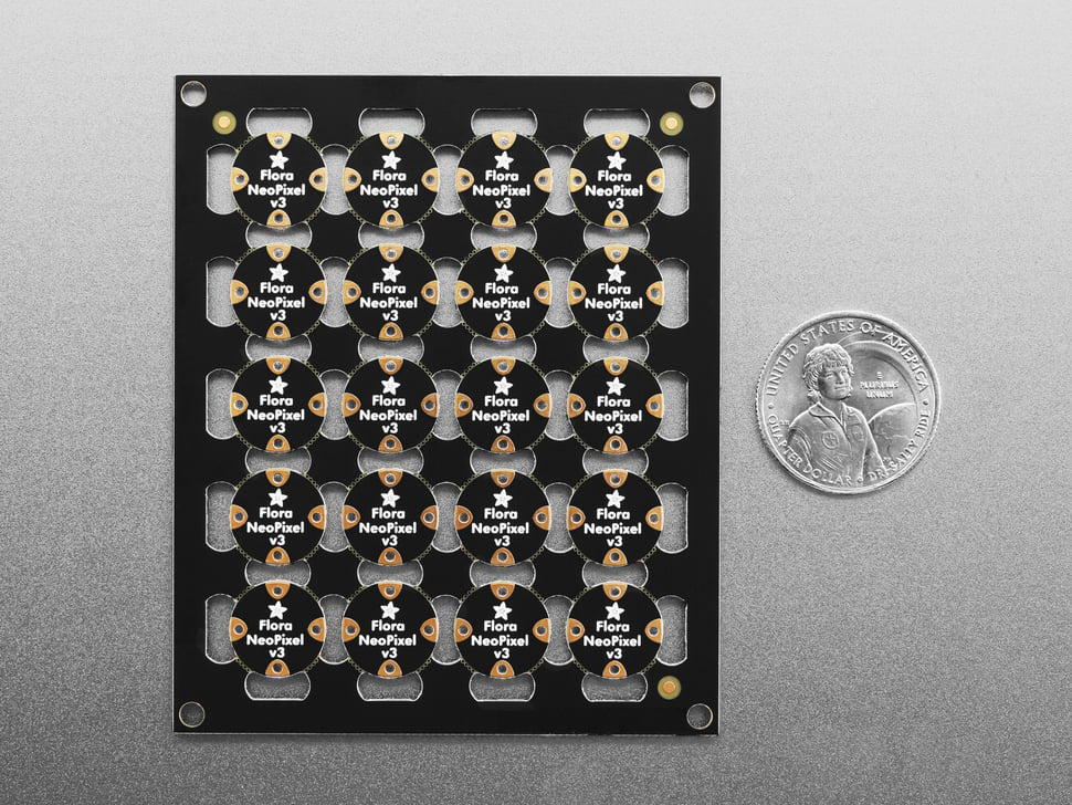 Back of PCB sheet of 20 break-off LEDs next to US quarter for scale