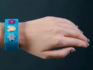 Video of assembled and powered on Programmable Wearable Electronic Wristband on a white woman's wrist. The LEDs glow in order.