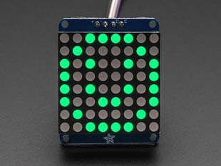 Adafruit Small 1.2" 8x8 Green LED Matrix w/I2C Backpack assembled and powered on. A pure green graphic smiley is displayed.