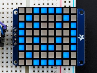 Close-up of Adafruit Small 1.2" 8x8 Blue LED Matrix w/I2C Backpack assembled and powered on. A blue graphic smiley is displayed.