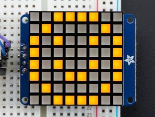 Soldered and assembled Small 1.2" 8x8 Ultra Bright Square yellow LED Matrix + Backpack on a breadboard powered by an Arduino Uno. The LED Matrix displays a yellow smiley.