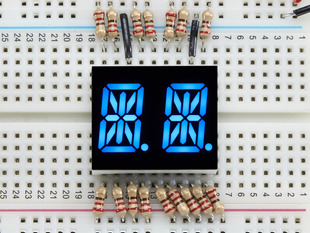 Blue Dual Alphanumeric Display module wired to breadboard, all segments lit