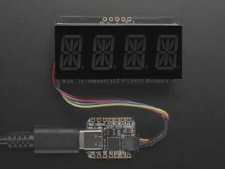Overhead video of an assembled 14-segment LED backpack, emitting the follow text in red LEDS: "AdaFruit 14-Segment Backpack"