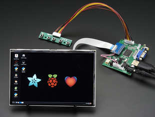 Angled shot of a HDMI 4 Pi: 7" Display. Display. The monitor displays a desktop background with a adafruit logo, raspberry logo, and a heart. 