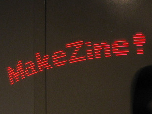 Mini POV long-capture image showing "MakeZine!" in red lights.