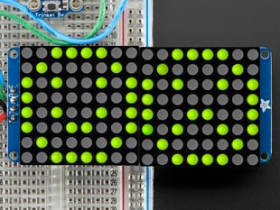 Close-up of Soldered and assembled 16x8 1.2" LED Matrix + Backpack - Ultra Bright Round Yellow-Green LEDs on a breadboard. The LED Matrices display a smiling emoji and a frowning emoji.