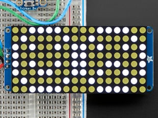 Close-up of Soldered and assembled 16x8 1.2" LED Matrix + Backpack - Ultra Bright Round White LEDs on a breadboard. The LED Matrices display a smiling emoji and a frowning emoji.