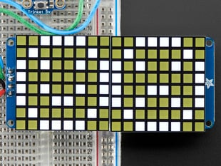 Close-up of Soldered and assembled 16x8 1.2" LED Matrix + Backpack - Ultra Bright Square White LEDs on a breadboard. The LED Matrices display a smiling emoji and a frowning emoji.