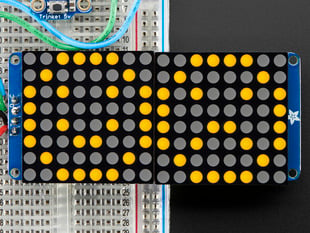 Close-up of Soldered and assembled 16x8 1.2" LED Matrix + Backpack - Ultra Bright Square Orange LEDs on a breadboard. The LED Matrices display a smiling emoji and a frowning emoji.