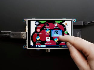 Top down view of a white hand touching the display of a PiTFT - Assembled 480x320 3.5" TFT+Touchscreen for Raspberry Pi.