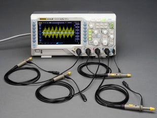 Oscilloscope powered on with four probes.