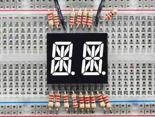 White Dual Alphanumeric Display module wired to breadboard, all segments lit