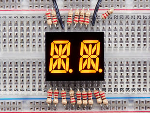Yellow Dual Alphanumeric Display module wired to breadboard, all segments lit