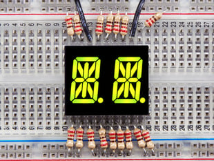 Yellow-green Dual Alphanumeric Display module wired to breadboard, all segments lit
