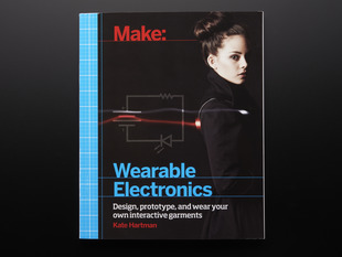 Front cover of Make: Wearable Electronics by Kate Hartman. Design, prototype, and wear your own interactive garments. Photograph of a young white woman with dark hair in a black high-collared robe.
