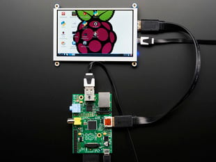 Top down view of a HDMI 5" Display Backpack - Without Touch connected to a Raspberry Pi powered by a USB. The HDMI screen displays a desktop image including the Raspberry Pi logo. 
