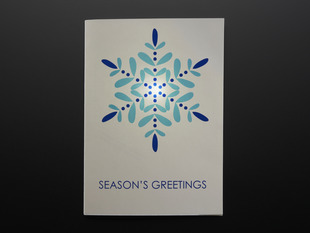 Front of Seasons Greetings card with snowflake design, and lit LED.