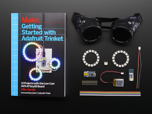 Getting Started with Adafruit Trinket book along with a collection of electronic parts included in kit.