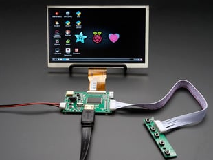 Front shot of a HDMI 4 Pi: 7" Display. The monitor displays a desktop background with a adafruit logo, raspberry logo, and a heart. 