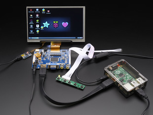 Front shot of a HDMI 4 Pi: 7" Display connected to a Raspberry Pi. The monitor displays a desktop background with a adafruit logo, raspberry logo, and a heart. 