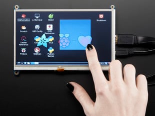 Black-manicured figure touching a HDMI 7" display.