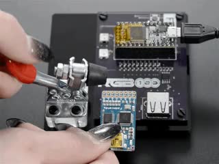 Video of a white hand manipulating a toggle clamp to press a blue rectangular board. 