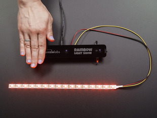 Hand on left end of Spikenzie labs Rainbow Light Show Kit, with LED strip red