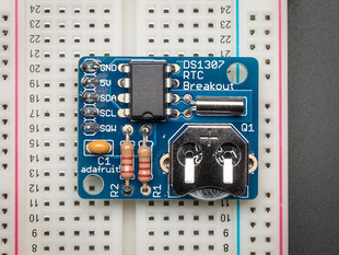 Top down view of a DS1307 Real Time Clock breakout board on a half sized white breadboard. 