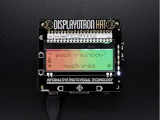Top view of assembled and powered on Pimoroni Display- O-Tron HAT on a Pi. The screen emits a rainbow gradient and the text: "such rainbow! pimoroni ftw"