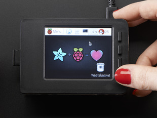 Red polished white hand holding a Faceplate and Buttons Pack placed on a Pi. 
