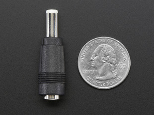 Top-down of 2.1mm to 2.5mm DC Barrel Plug Adapter next to US quarter for scale. 
