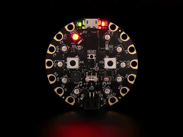 Video of a round microcontroller with lit up LEDs.