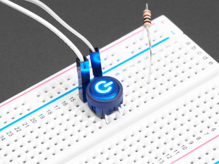 Close-up of a mini illuminated push-button with a blue power symbol installed in a half-size breadboard. Also are on the breadboard are two jumper wires and a resistor.