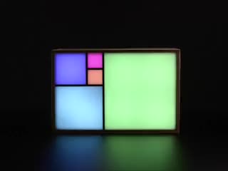 Artistic clock with 5 large squares on front glowing in rainbow colors